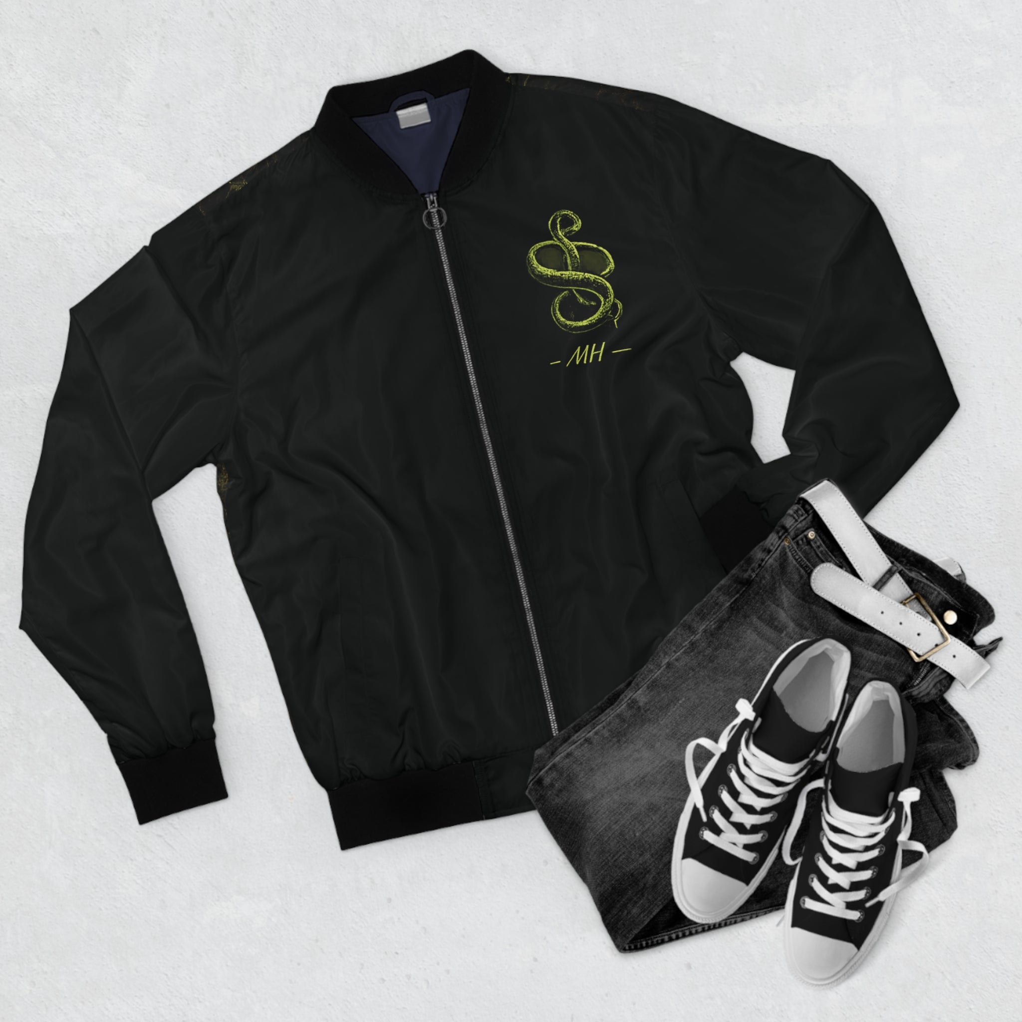 Black bomber jacket with red text and logo, black jeans, and black sneakers on a light gray background